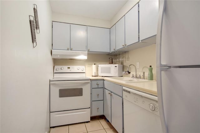 kitchen with white appliances, sink, and light tile patterned floors