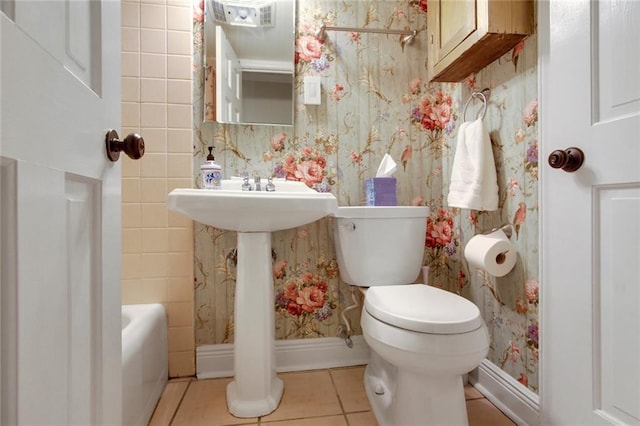 bathroom featuring shower / bath combo with shower curtain, toilet, and tile patterned floors