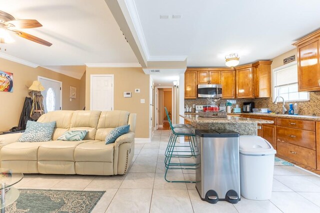 kitchen featuring a kitchen island, decorative backsplash, crown molding, and stainless steel appliances