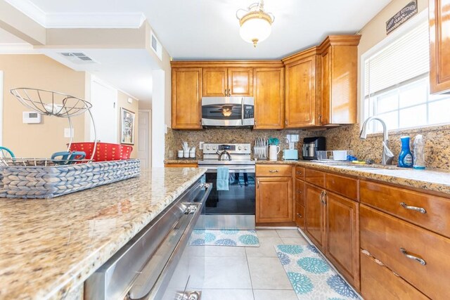 kitchen featuring stainless steel appliances, tasteful backsplash, light stone counters, and ornamental molding