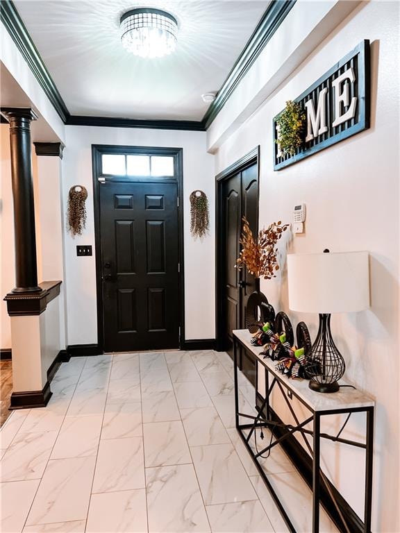 entrance foyer featuring ornate columns and crown molding