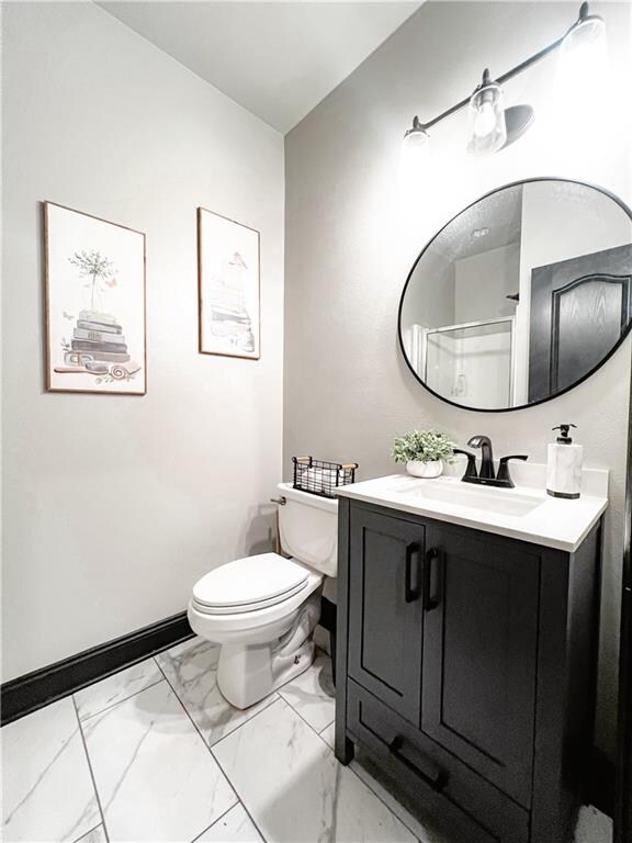 bathroom with toilet, vanity, and a shower