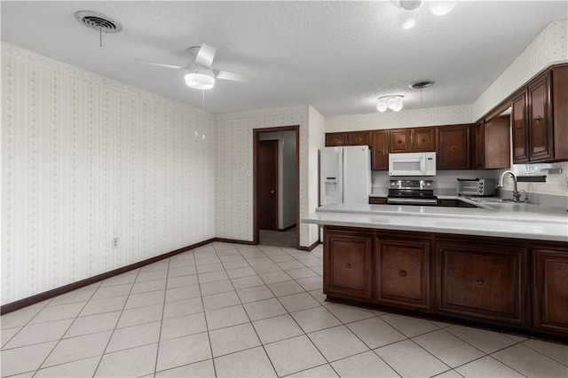 kitchen featuring white appliances, sink, ceiling fan, dark brown cabinetry, and a textured ceiling