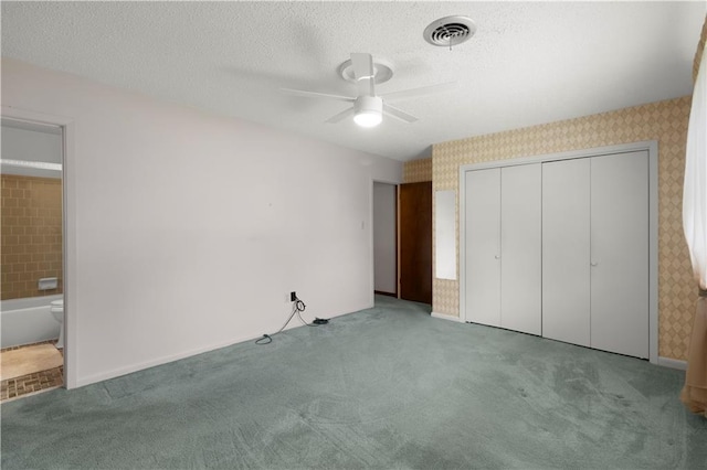 unfurnished bedroom featuring light carpet, a textured ceiling, ceiling fan, and a closet