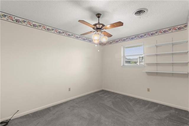 unfurnished room with ceiling fan, a textured ceiling, and dark colored carpet