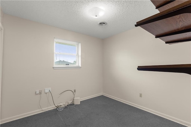 empty room with a textured ceiling and carpet floors