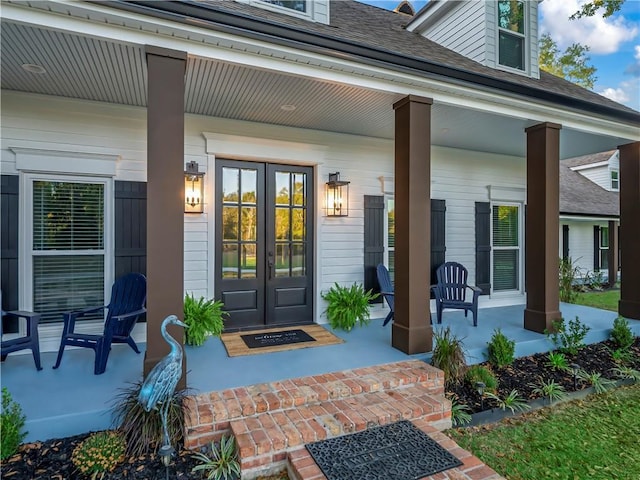 view of exterior entry with a porch and french doors