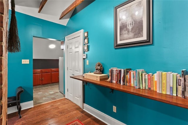 hallway featuring wood-type flooring and lofted ceiling