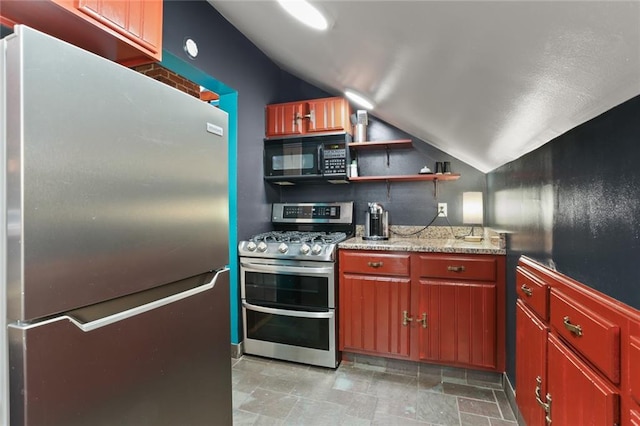 kitchen with appliances with stainless steel finishes, lofted ceiling, and light stone countertops