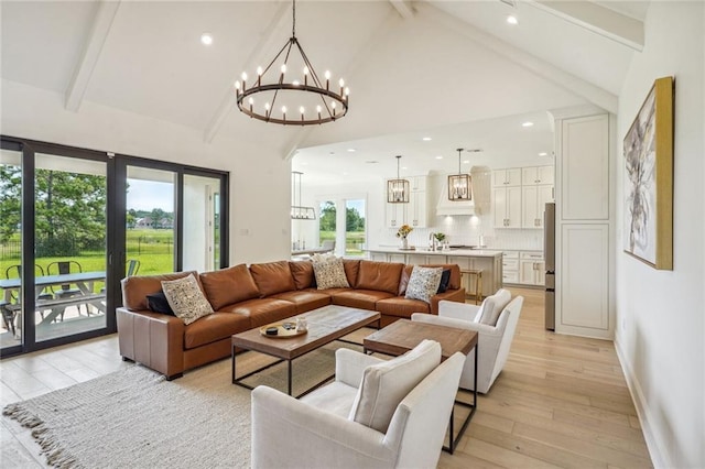 living room featuring a chandelier, sink, high vaulted ceiling, beamed ceiling, and light hardwood / wood-style flooring