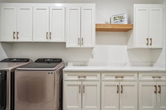 laundry room with washing machine and dryer and cabinets