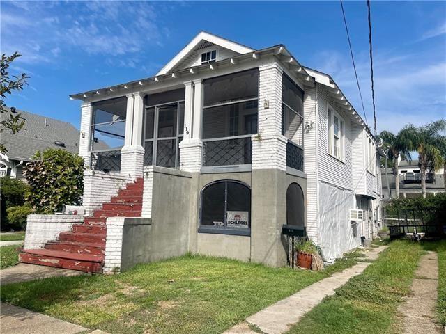 119 Elmeer Ave, Metairie, LA 70005 - view of front facade with stairway, a front lawn, and a sunroom