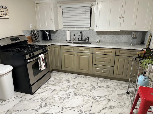 kitchen featuring gas stove, decorative backsplash, sink, and white cabinets