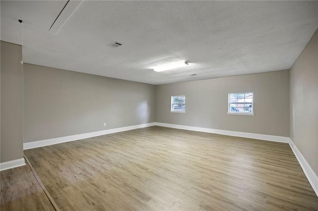 spare room featuring a textured ceiling and wood-type flooring