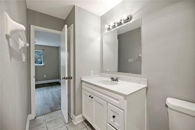 bathroom with tile patterned flooring, vanity, and toilet