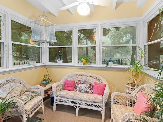 sunroom featuring ceiling fan and beam ceiling