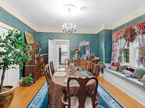 dining room with wood-type flooring and a chandelier