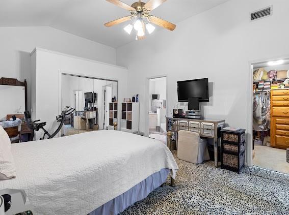 carpeted bedroom featuring ceiling fan, a closet, and vaulted ceiling