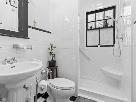 full bathroom featuring tile walls, toilet, and walk in shower