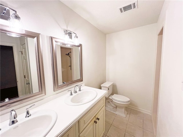 bathroom with tile patterned flooring, vanity, and toilet