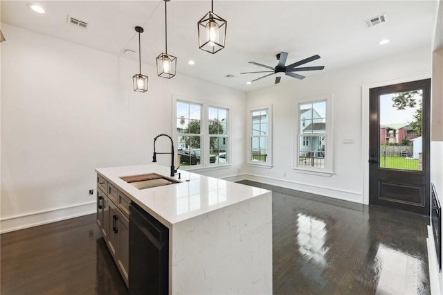 kitchen featuring dark hardwood / wood-style floors, an island with sink, hanging light fixtures, sink, and ceiling fan