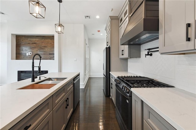 kitchen featuring decorative light fixtures, appliances with stainless steel finishes, sink, dark hardwood / wood-style floors, and exhaust hood