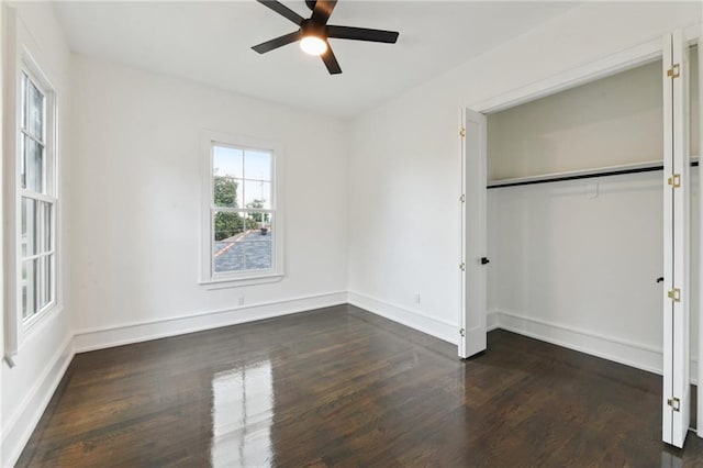 unfurnished bedroom with dark hardwood / wood-style flooring, ceiling fan, and a closet