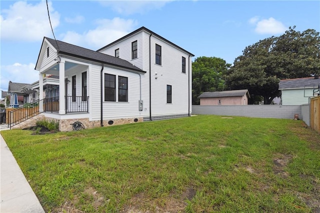 view of side of property with a lawn and covered porch