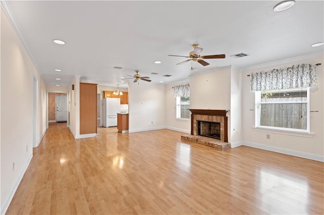 unfurnished living room with crown molding, ceiling fan, light hardwood / wood-style flooring, and a brick fireplace