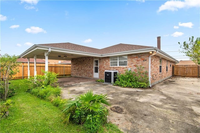 rear view of property featuring cooling unit, a lawn, and a patio area