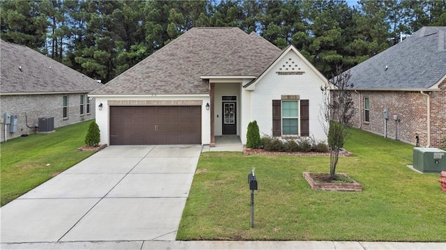 view of front facade featuring a garage, cooling unit, and a front lawn