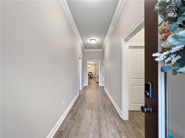 hall with crown molding and light hardwood / wood-style flooring