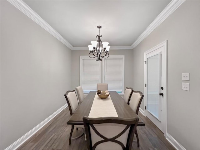 dining room featuring dark hardwood / wood-style floors, a chandelier, and crown molding