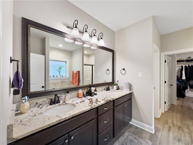 bathroom featuring walk in shower, wood-type flooring, and vanity