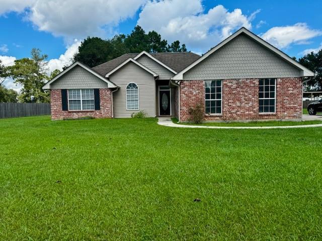 single story home with brick siding, fence, and a front yard