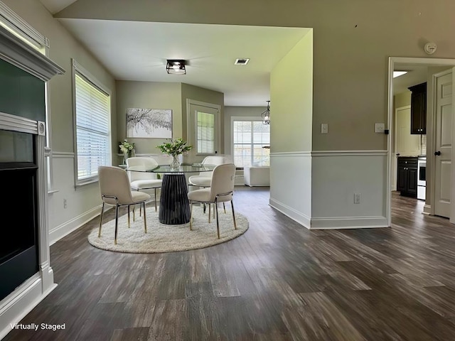 dining space with dark wood-style floors, visible vents, plenty of natural light, and baseboards