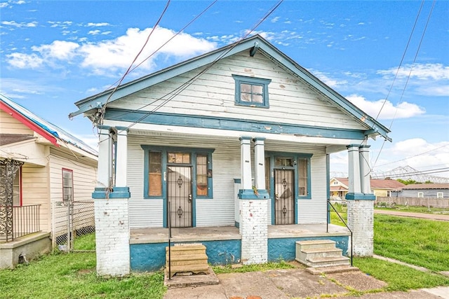 bungalow featuring a front yard and covered porch