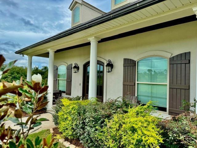 view of exterior entry featuring covered porch