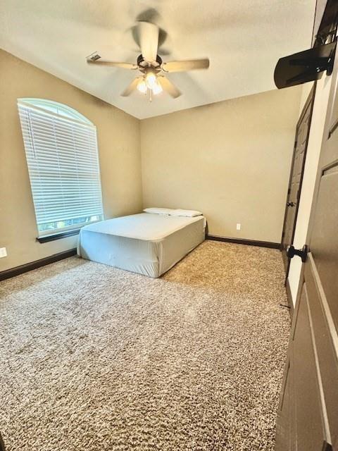 unfurnished bedroom featuring ceiling fan and light carpet