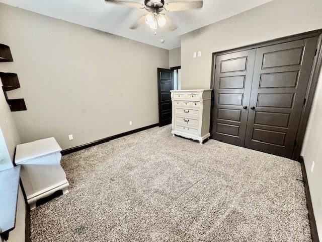 unfurnished bedroom featuring ceiling fan, a closet, and light carpet