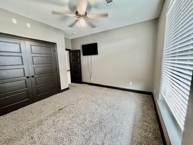 unfurnished bedroom with a closet, ceiling fan, and carpet