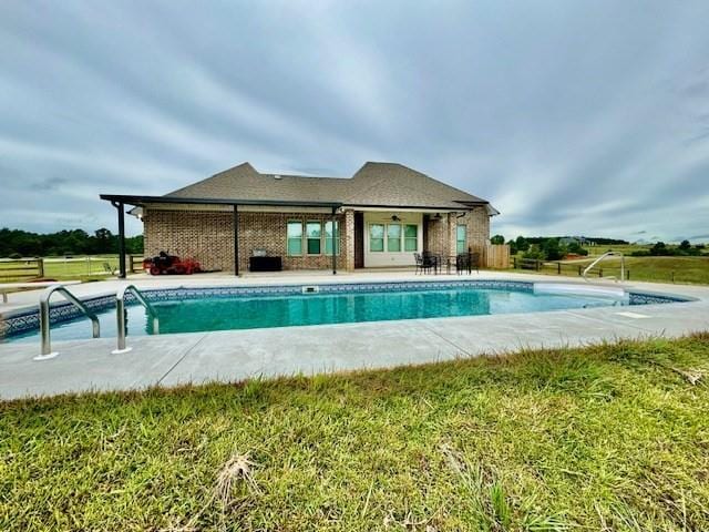 view of swimming pool with a patio area and a yard