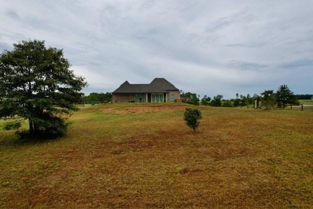 view of front facade with a front lawn and a rural view