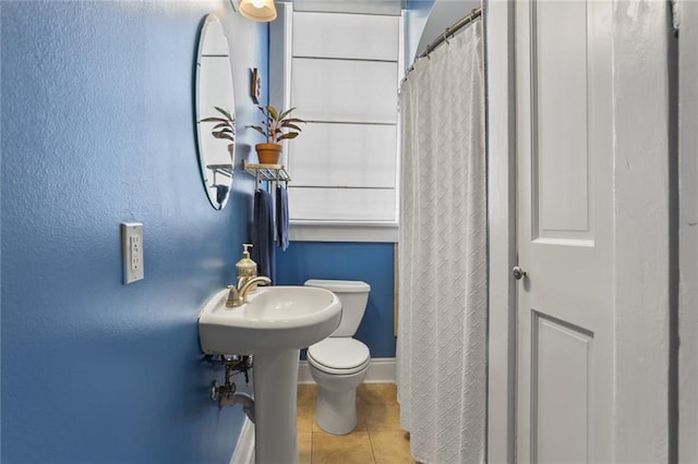 bathroom with toilet and tile patterned floors