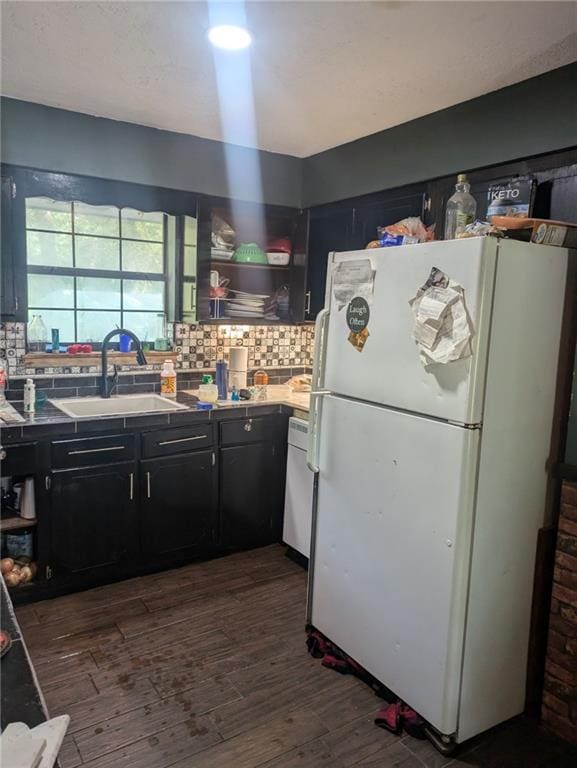 kitchen with sink, dark hardwood / wood-style floors, white fridge, and decorative backsplash