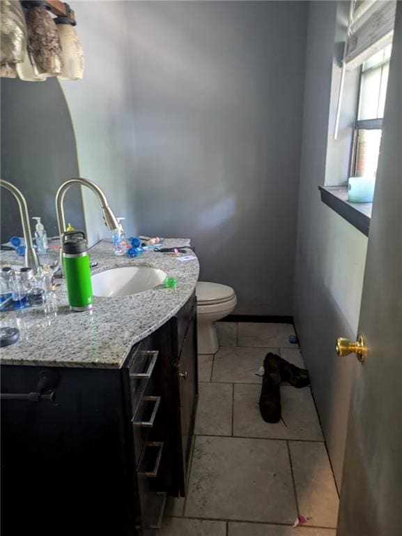 bathroom with tile patterned flooring, vanity, and toilet