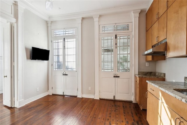 kitchen featuring light stone countertops, dark hardwood / wood-style flooring, and crown molding