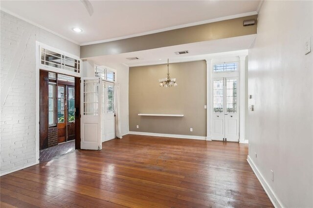 foyer featuring dark wood-type flooring, crown molding, french doors, and an inviting chandelier