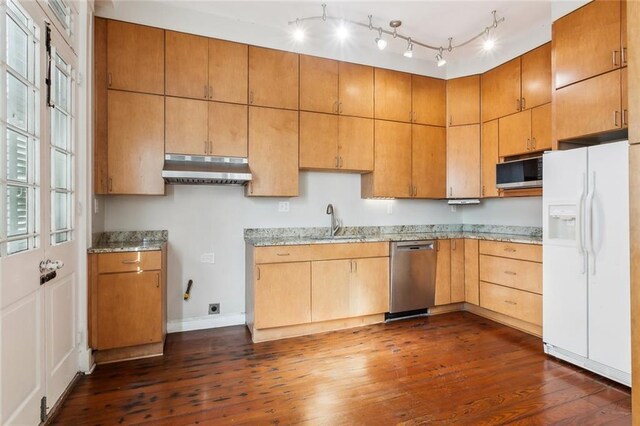 kitchen featuring appliances with stainless steel finishes, dark hardwood / wood-style flooring, light stone counters, and sink