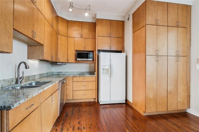 kitchen with light stone countertops, sink, dark hardwood / wood-style floors, and stainless steel appliances